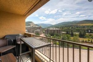 a balcony with a table and chairs and mountains at Unit 520 - 3br condo with balcony views in Avon