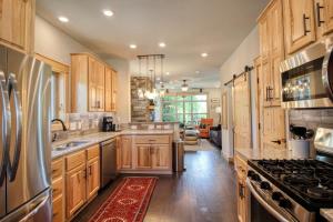 a large kitchen with wooden cabinets and a stove at Modern 3bd cabin in Edgewater in Granby