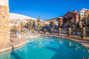 una piscina en un complejo con una montaña cubierta de nieve en 1bd 272 Perfect Location with Pool, en Crested Butte