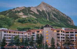 a building with a mountain in the background at Studio at Perfect Location Unit 412 with Pool and Hot Tub in Crested Butte