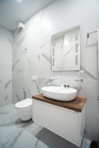 een witte badkamer met een wastafel en een toilet bij Tirana Elite Apartments in Tirana