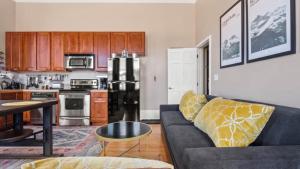 a living room with a couch and a kitchen at Beautiful Mountain Views in Iconic Building in Leadville