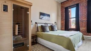 a bedroom with a bed and a brick wall at Beautiful Mountain Views in Iconic Building in Leadville