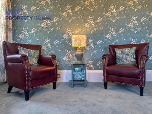 two chairs and a lamp in a living room at Cross Wynd view in Hawick +1 photo