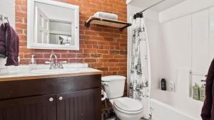 a brick bathroom with a toilet and a sink at Papa's Place - blocks from downtown in Leadville