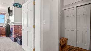 a hallway with two white doors and a brick fireplace at Papa's Place - blocks from downtown in Leadville
