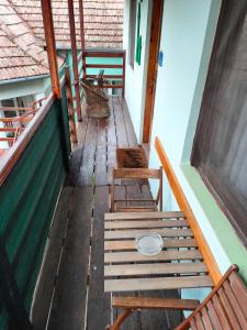 un porche vacío con 2 sillas y una cesta en Joky Katona Rooms & Apartments, en Palić