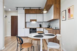 a kitchen with a white table and chairs at RentPlanet - Apartament Międzynarodowa in Warsaw