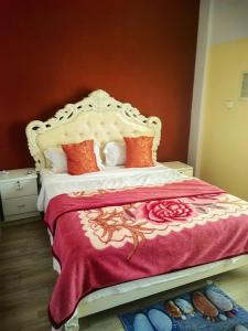 a bedroom with a large bed with a red wall at hongyuanprimierhotel in Accra