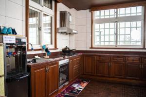 cocina con armarios de madera y nevera negra en 宜蘭 星居 包層公寓, en Yilan City