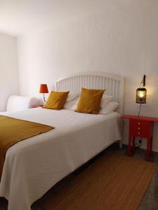 メルトラにあるCasa dos Corvosのベッドルーム(白い大型ベッド、黄色い枕付)