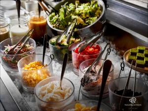 a buffet filled with bowls of different types of food at Daiwa Roynet Hotel Nishi-Shinjuku PREMIER in Tokyo