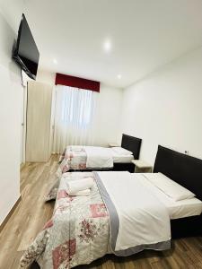 a room with two beds and a flat screen tv at Dream Hub in Mestre