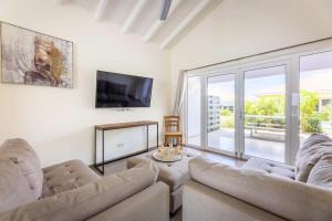 uma sala de estar com 2 sofás e uma televisão de ecrã plano em Sunny Apartment Blije Rust em Dorp Sint Michiel