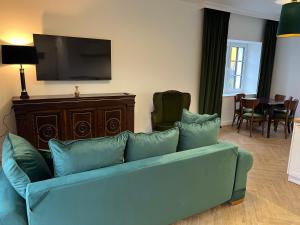 a living room with a blue couch and a flat screen tv at Apartamenty pod Dębami in Bielsko-Biała