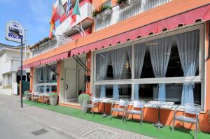 a restaurant with tables and chairs outside of a building at Hotel Rex in Caorle