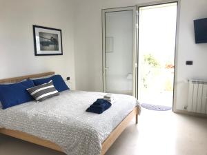Schlafzimmer mit einem Bett und einer Glasschiebetür in der Unterkunft Valle dell Idro Otranto in Casamassella