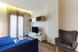 uma sala de estar com um sofá azul e uma cadeira em #Danae Apt by halu! Apartments em Tessalônica