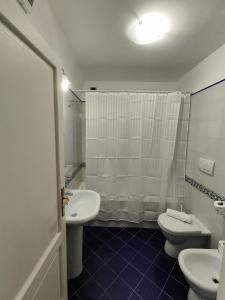 a bathroom with two toilets and a sink and a shower at Androsa Apartments in Amalfi