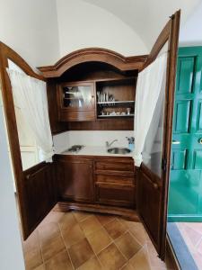 een keuken met houten kasten en een wastafel bij Androsa Apartments in Amalfi