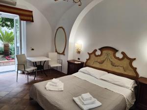 a bedroom with a bed and a table and a mirror at Androsa Apartments in Amalfi