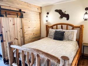 Un dormitorio con una cama de madera con un caballo en la pared en New Listing - Slopeside condo with Private Hot Tub en Granby