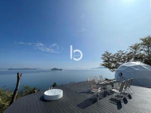 吴市2 BR Villa with Breathtaking Ocean View for 10 Ppl的水景甲板上的桌椅