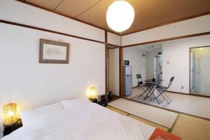 広島市にあるDai3Himawari by b hotel - Best location ! 1 min walk to Peace Park Dome -701のベッドルーム(白いベッド1台付)、リビングルームが備わります。