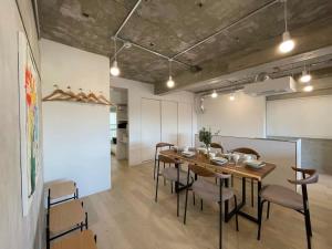 a dining room with a wooden table and chairs at bHOTEL Dai3Himawari - 30 sec to PeacePark!! HUGE comfort house Up to 10p in Hiroshima