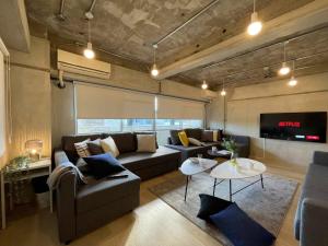 a living room with a couch and a table at bHOTEL Dai3Himawari - 30 sec to PeacePark!! HUGE comfort house Up to 10p in Hiroshima
