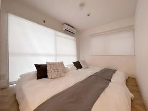 a large bed in a room with a large window at bHOTEL Dai3Himawari - 30 sec to PeacePark!! HUGE comfort house Up to 10p in Hiroshima