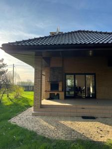 a small brick house with a large window at Willa w Piszu in Pisz