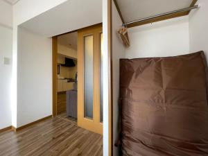 広島市にあるbHOTEL Dai3Himawari - 2BR good for 6PPL overlooking Peace Park with WIFI!のベッド付きの部屋、ドア付きの廊下