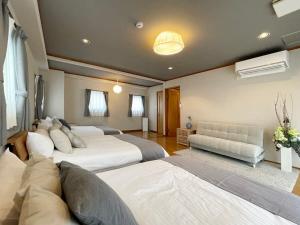 a large bedroom with two beds and a couch at bHOTEL M bld - Beautiful, spacious apartment next to Peace Park in Hiroshima