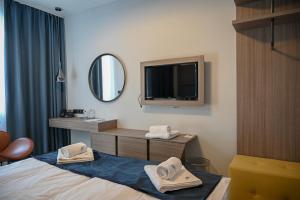 a hotel room with a bed and a mirror at NN Boutique Hotel**** in Tiszaújváros
