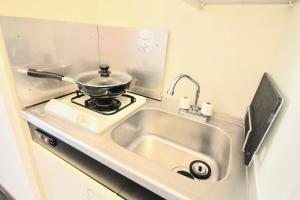 a kitchen with a sink and a pot on a stove at bHOTEL Pacifica - 30sec walk to PeacePark, Beautiful studio in Hiroshima