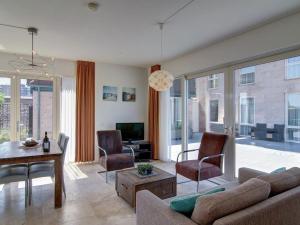 - un salon avec un canapé et une table dans l'établissement Luxury apartment in a residence right on the boulevard and the beach, à Egmond aan Zee