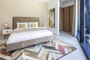 1 dormitorio con 1 cama grande y 1 alfombra en Frank Porter - Marquise Square, en Dubái