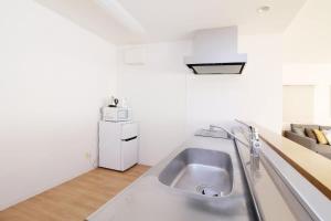a kitchen with a stainless steel sink in a room at Marumasa by b hotel - Large 2BR Apt 10PPL near Peace Park 301 in Hiroshima