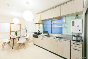 a kitchen with a sink and a table with chairs at bHOTEL Marumasa - Spacious next to PeacePark Family Condo Up to 13 P in Hiroshima
