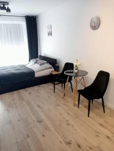 um quarto com uma cama, uma mesa e cadeiras em Apartament Diament 1 - Jezioro Nyskie em Nysa