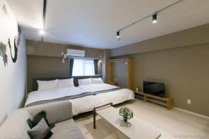 a bedroom with a large bed and a tv at bHOTEL Origaminn 402 - 5 mins PeacePark in Hiroshima