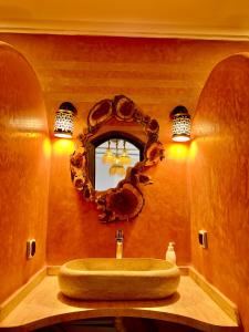a bathroom with a sink and a mirror at Grand Canyon Lodge Dades in Aït Idaïr