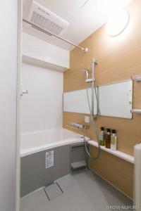 La salle de bains est pourvue d'un lavabo et d'une douche. dans l'établissement bHOTEL Origaminn 402 - 5 mins PeacePark, à Hiroshima