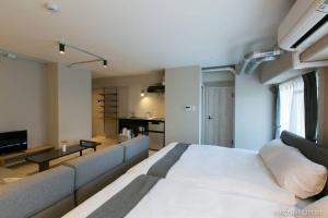 Un dormitorio con una gran cama blanca y un sofá. en Origaminn 301 by b hotel - 5 mins Peace Park, en Hiroshima