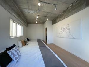 a room with a bed and a painting on the wall at b hotel M's lea - Spacious Family apartment next to Peace Park in Hiroshima