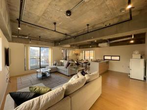 a large living room with a couch and a kitchen at b hotel M's lea - Spacious Family apartment next to Peace Park in Hiroshima