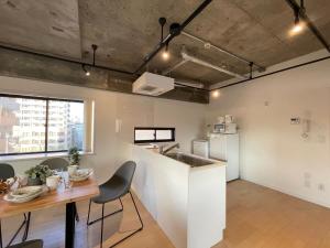 a kitchen and dining room with a table and a counter at b hotel M's lea - Spacious Family apartment next to Peace Park in Hiroshima