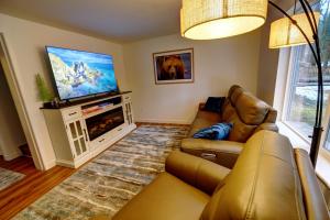 uma sala de estar com um sofá e uma televisão de ecrã plano em Green Valley Getaway - 2br Family Friendly Home em Mendenhaven