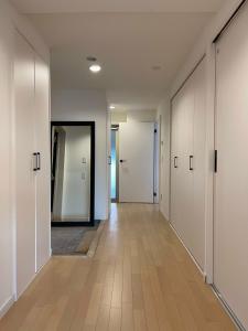 an empty hallway with white walls and wooden floors at b hotel M's lea - Spacious Family apartment next to Peace Park in Hiroshima